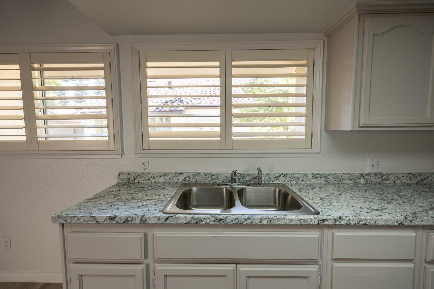 3700 Tully Road, Unit 5 Modesto, CA 95356 - Photo 9 of 38 a kitchen with granite countertop cabinets sink and window