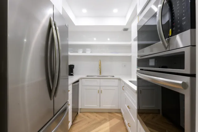 a kitchen with white cabinets and stainless steel appliances