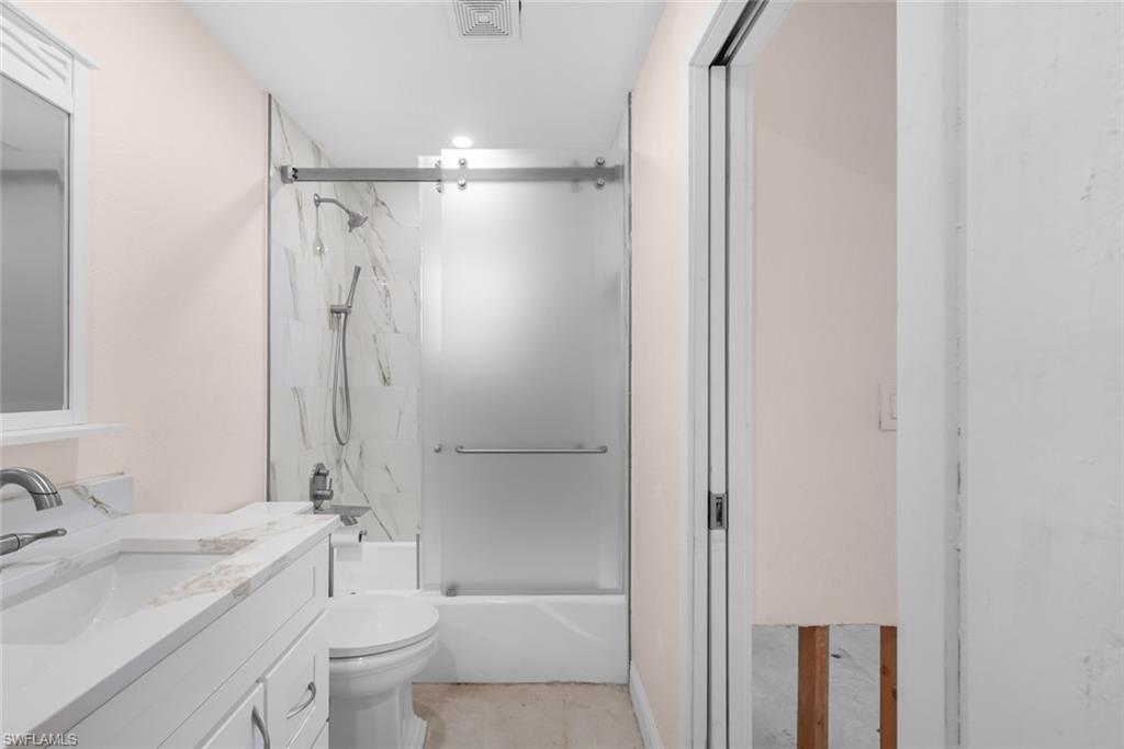 24 Rivard Road, Unit 12 Naples, FL 34112 - Photo 17 of 27 Full bathroom featuring enclosed tub / shower combo, vanity, and toilet