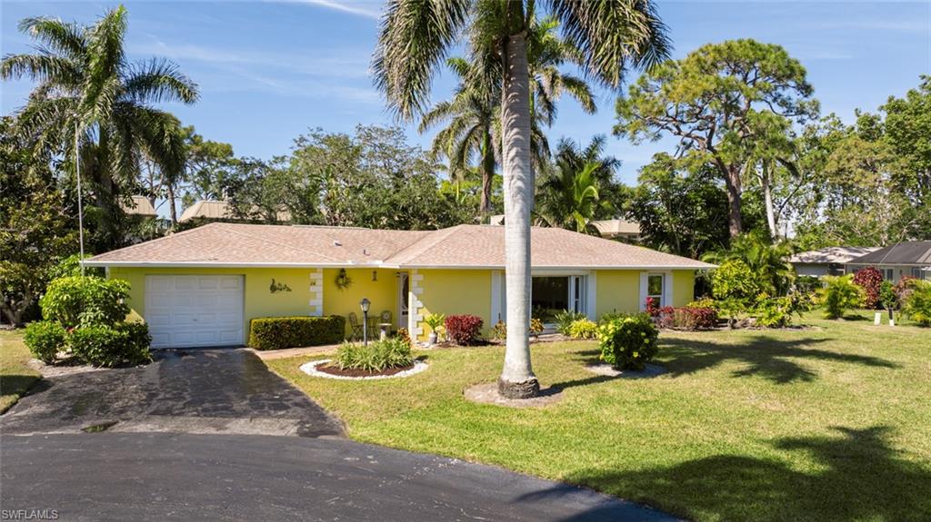 Single story home with a garage and a front yard