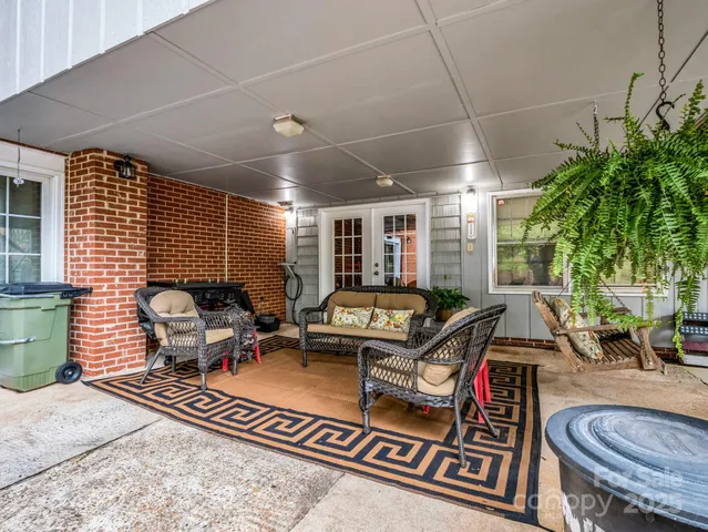 a view of a patio with table and chairs potted plants and large tree