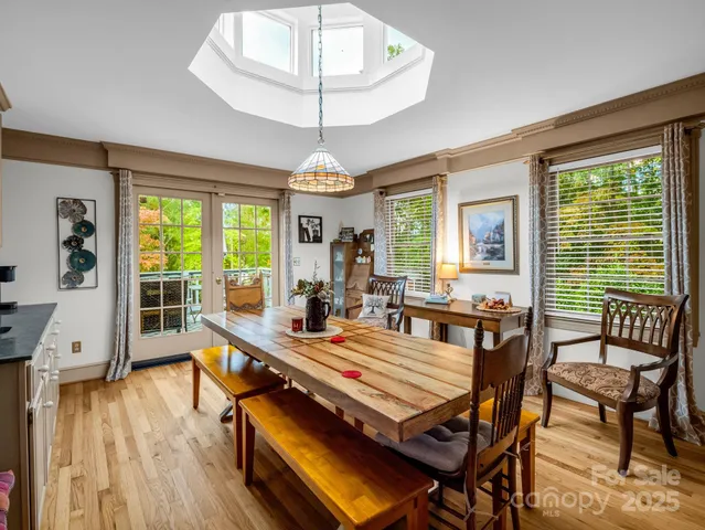 a view of a dining room with furniture a chandelier and wooden floor