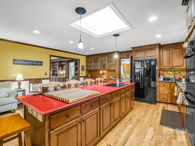 a kitchen with stainless steel appliances granite countertop a refrigerator a stove and a sink with wooden floor