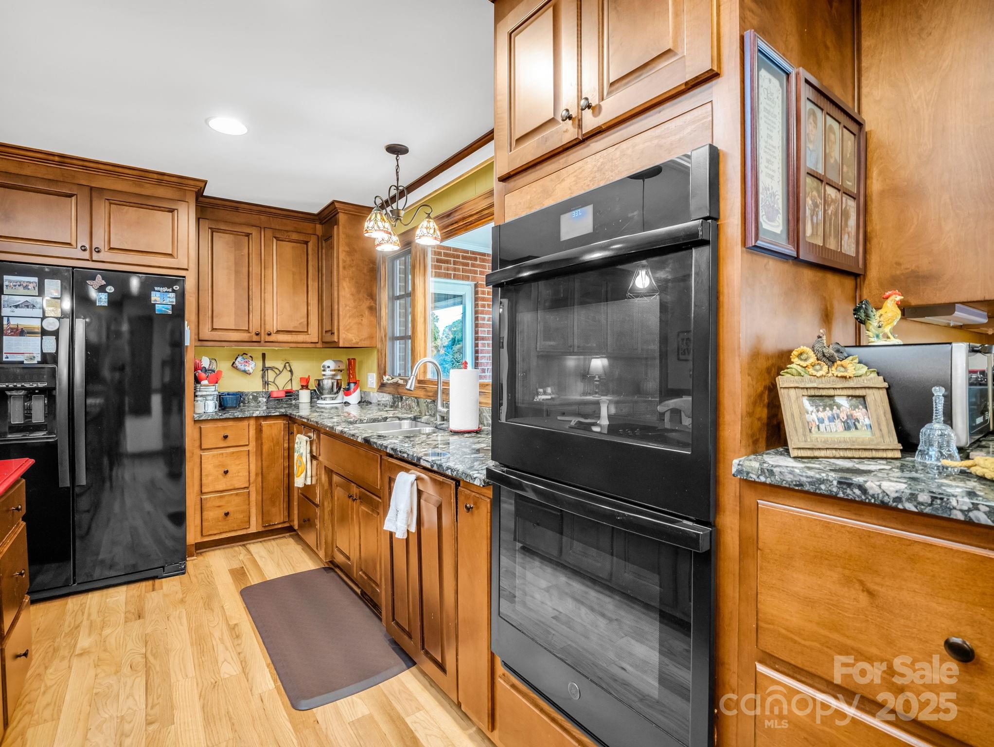 343 Nebraska Street Spindale, NC 28160 - Photo 30 of 46 a kitchen with stainless steel appliances granite countertop a refrigerator a stove and a sink with wooden floor