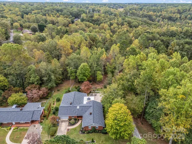 an aerial view of residential houses with outdoor space and trees