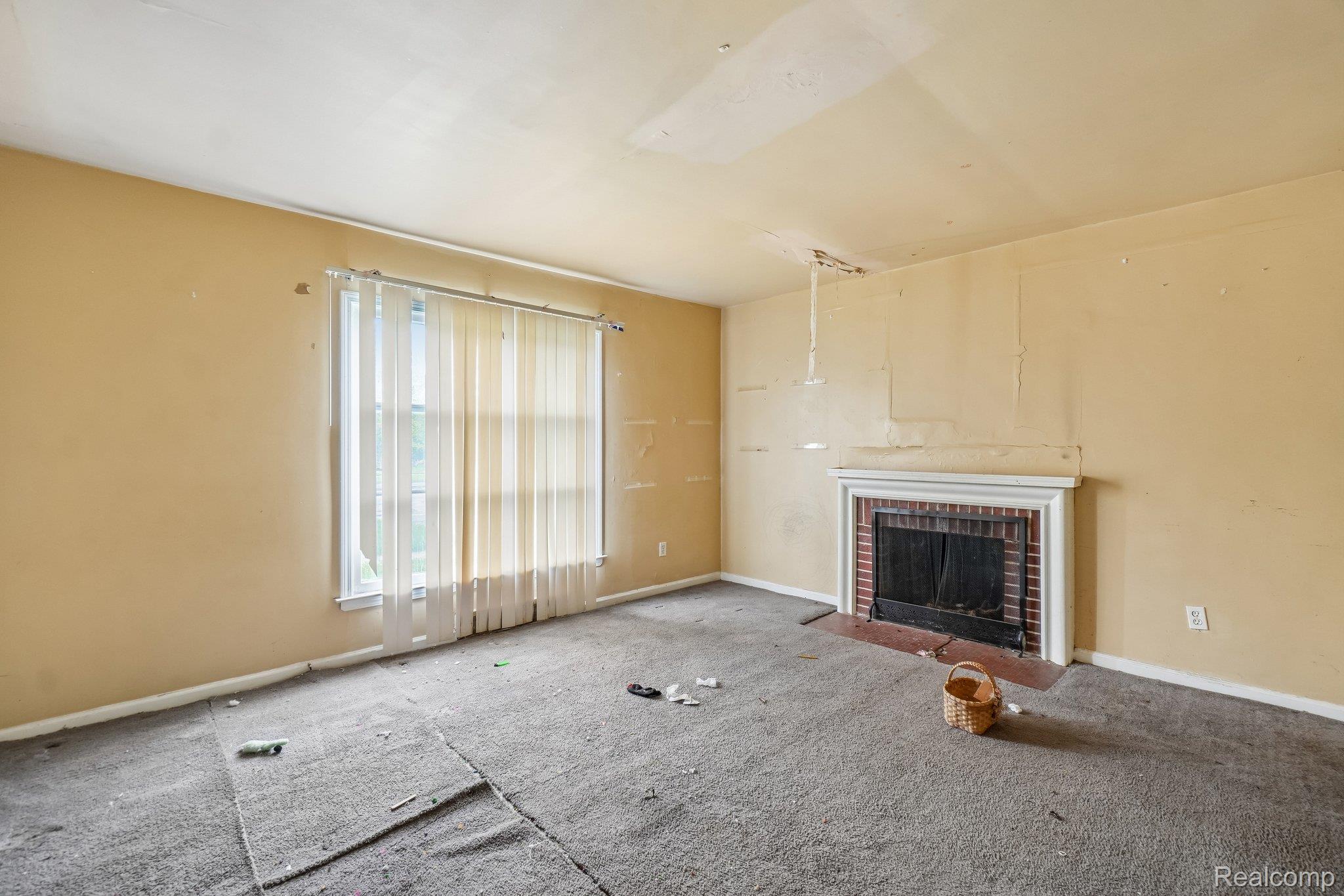 Unfurnished living room featuring carpet flooring and a fireplace