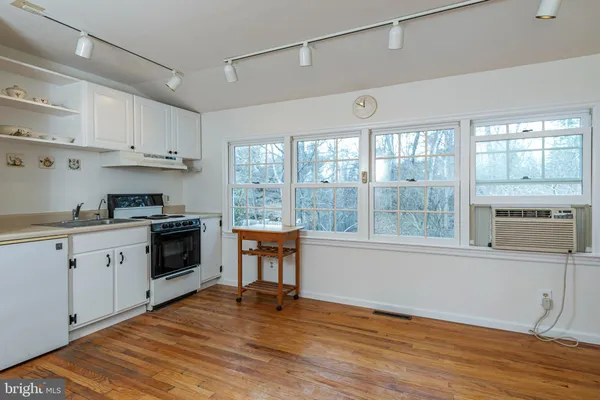 a kitchen with granite countertop a stove a sink and a refrigerator