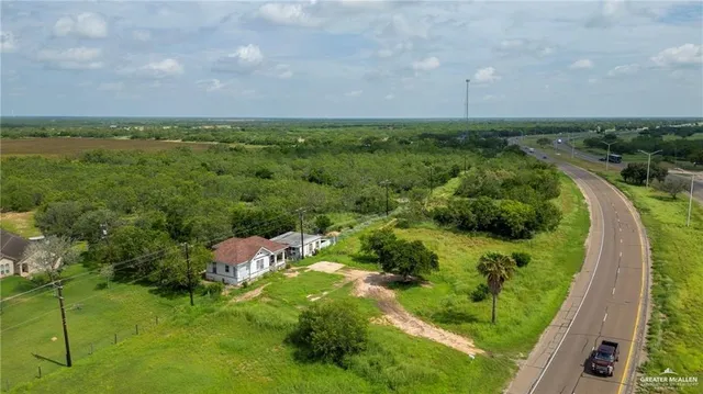 an aerial view of residential houses with outdoor space and trees