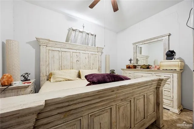 a bedroom with a bed a chandelier and dresser