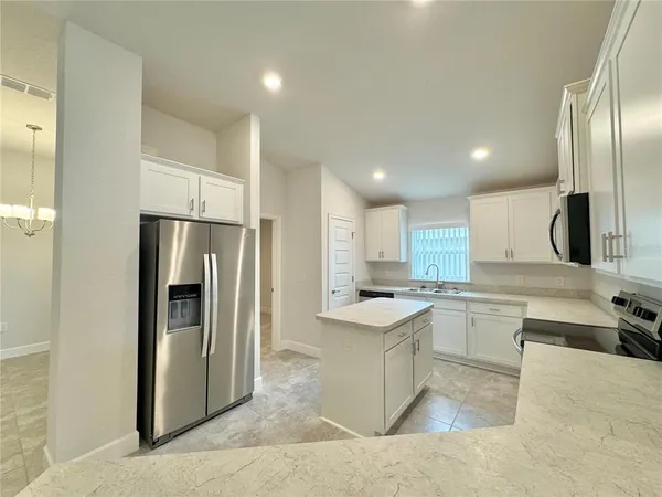 a kitchen with a refrigerator a sink and a stove top oven