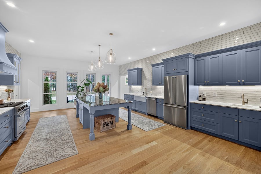 280 Ice Valley Road Osterville, MA 02655 - Photo 21 of 42 a kitchen with stainless steel appliances kitchen island granite countertop a refrigerator oven a sink dishwasher and a dining table with wooden floor