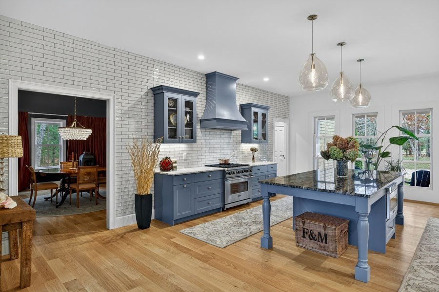 280 Ice Valley Road Osterville, MA 02655 - Photo 22 of 42 a kitchen with stainless steel appliances kitchen island granite countertop a refrigerator a stove a sink dishwasher and a dining table with wooden floor