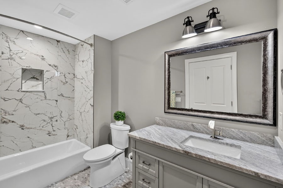 280 Ice Valley Road Osterville, MA 02655 - Photo 32 of 42 a bathroom with a granite countertop sink a toilet and a bathtub