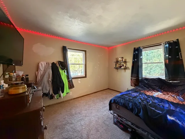 a bedroom with bed and a flat tv screen on dresser