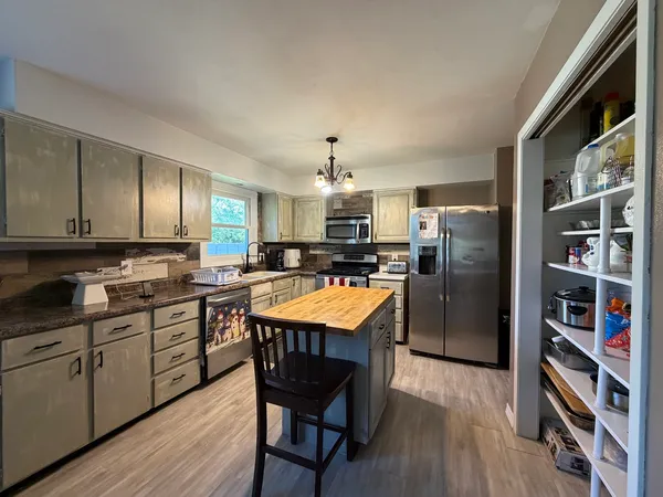 a kitchen with refrigerator cabinets dining table and chairs