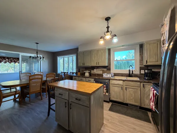 a kitchen with granite countertop a sink stove and cabinets