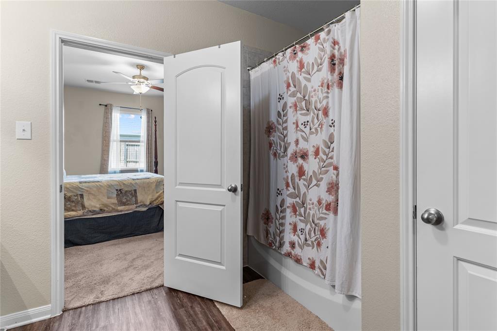 3005 Parker Road Anna, TX 75409 - Photo 10 of 17 White paneled door opening into a bedroom with carpeted flooring and a ceiling fan