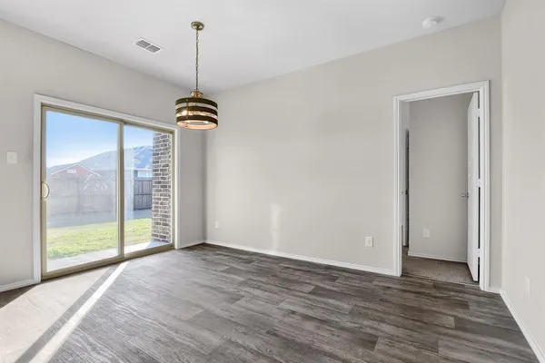 a view of a room with wooden floor and windows