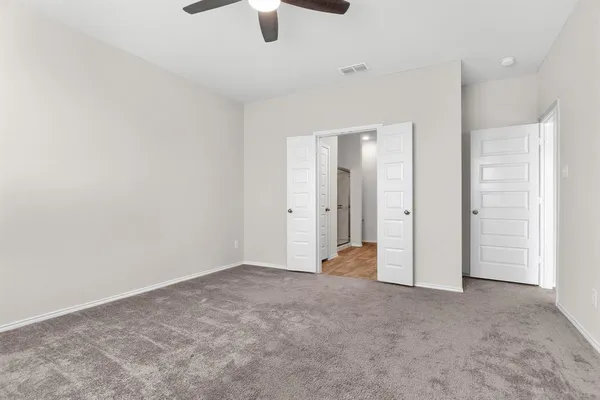 an empty room with closet and windows