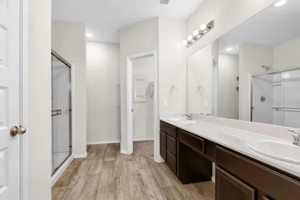 a spacious bathroom with a double vanity sink mirror and shower