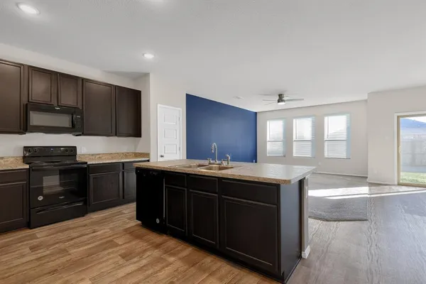 a kitchen with stainless steel appliances granite countertop a stove a sink and a microwave