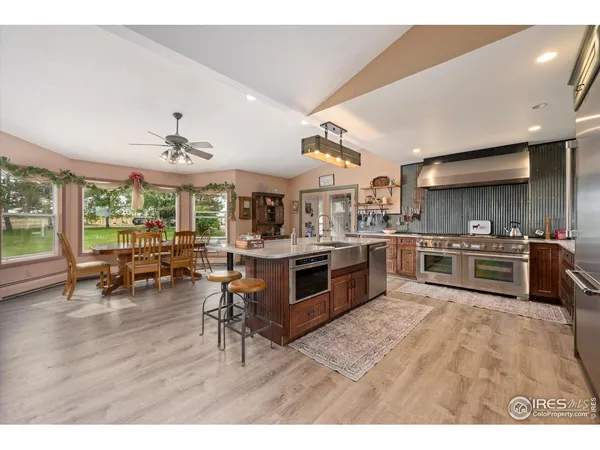a kitchen with stainless steel appliances kitchen island granite countertop a sink cabinets and wooden floor