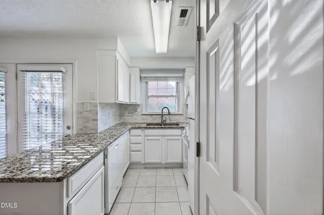 a bathroom with a granite countertop sink a toilet and shower