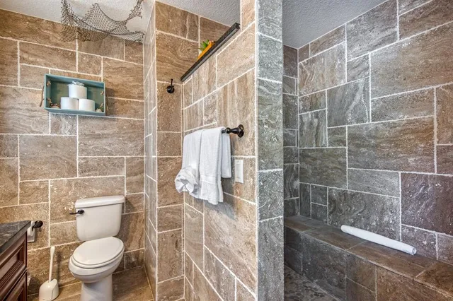 a bathroom with a toilet and a shower