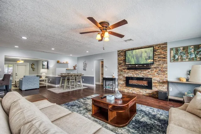 a living room with furniture a fireplace and a flat screen tv