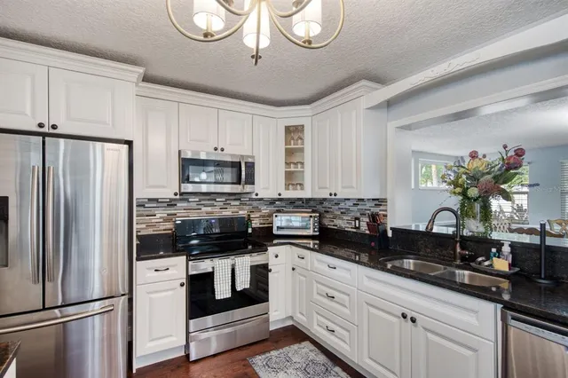 a kitchen with appliances a sink cabinets and a window