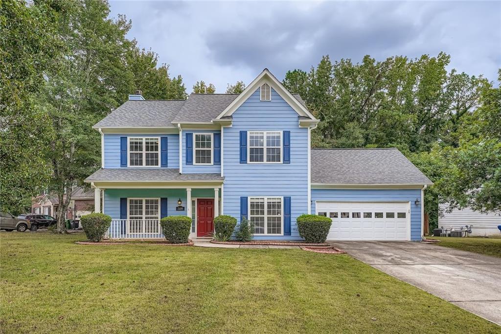 a view of a house with a yard and potted plants