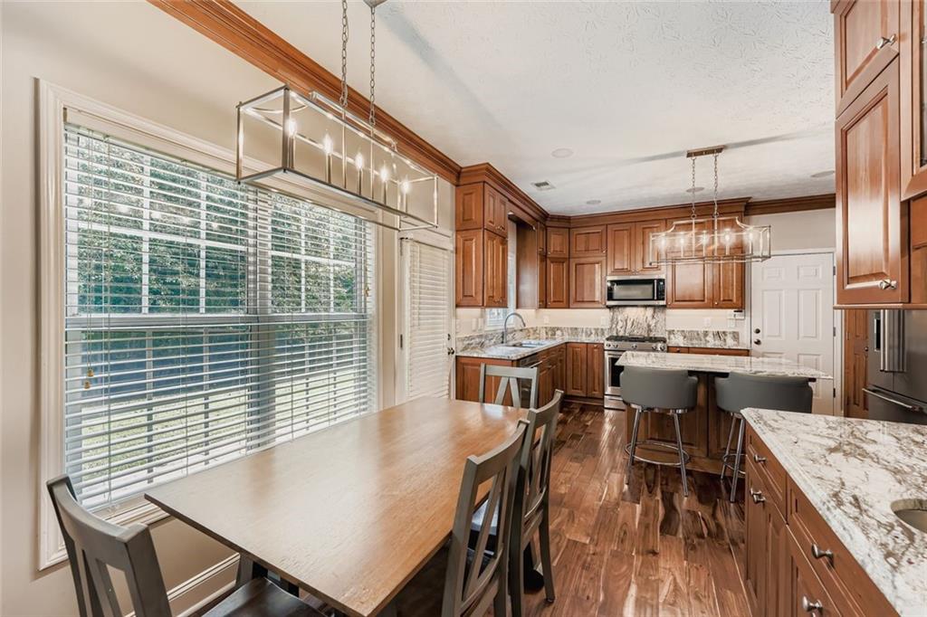 2409 Caneridge Way Southwest Marietta, GA 30064 - Photo 11 of 28 a open kitchen with stainless steel appliances granite countertop a stove a kitchen island a table and chairs