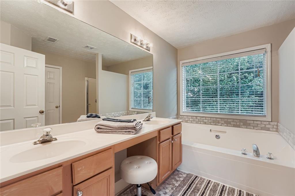 2409 Caneridge Way Southwest Marietta, GA 30064 - Photo 19 of 28 a bathroom with a tub sink and mirror