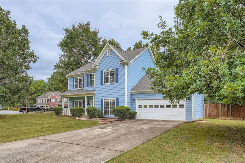 2409 Caneridge Way Southwest Marietta, GA 30064 - Photo 2 of 28 a front view of a house with a garden and trees