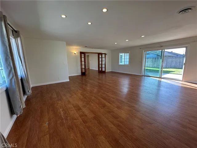an empty room with wooden floor and a window