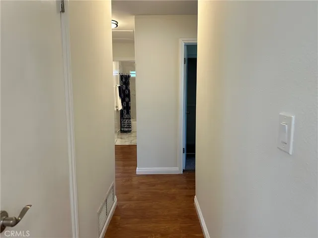 a view of a hallway with wooden floor and closet