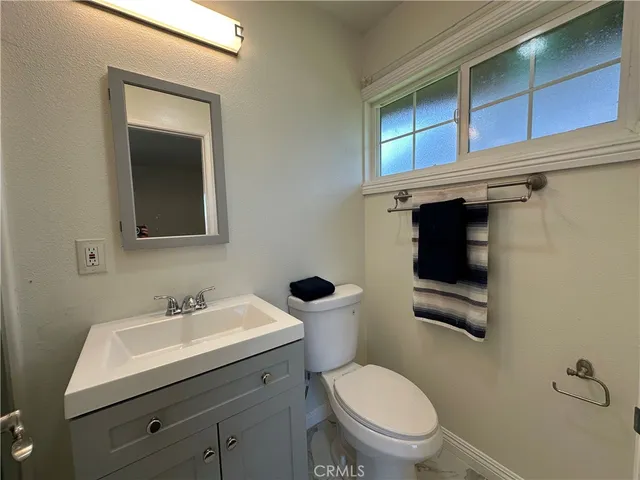 a bathroom with a toilet a sink and mirror
