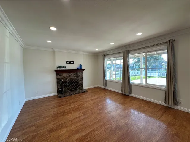 a view of an empty room with a fireplace and a window