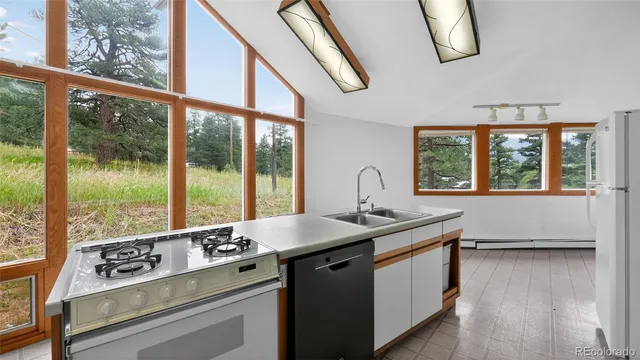 a view of a kitchen counter top a stove and wooden floor