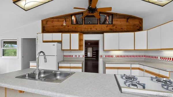a kitchen with stainless steel appliances granite countertop a sink and a refrigerator