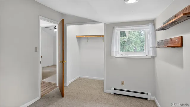 an empty room with a window and a ceiling fan
