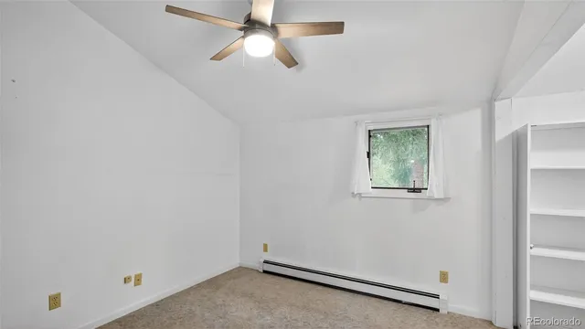 an empty room with a window and a fan