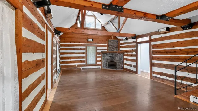 a view of an empty room with a fireplace and a window