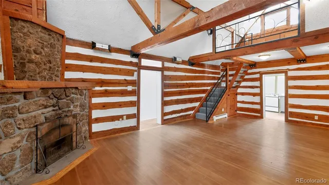 a view of an empty room with stairs and a fireplace