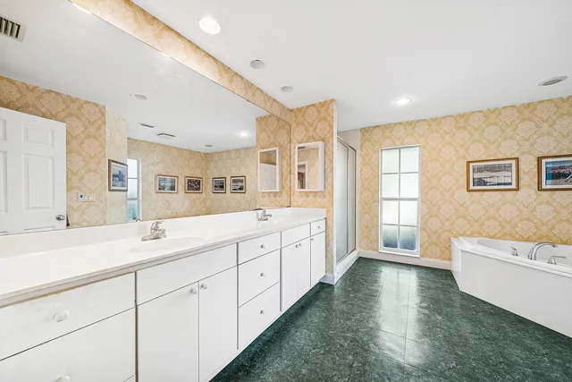 a bathroom with a tub a window and a sink
