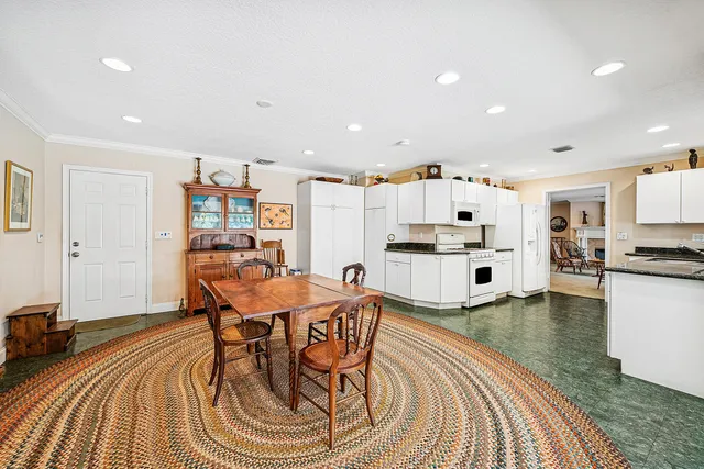 a large kitchen with granite countertop a large counter top space a sink stainless steel appliances and cabinets