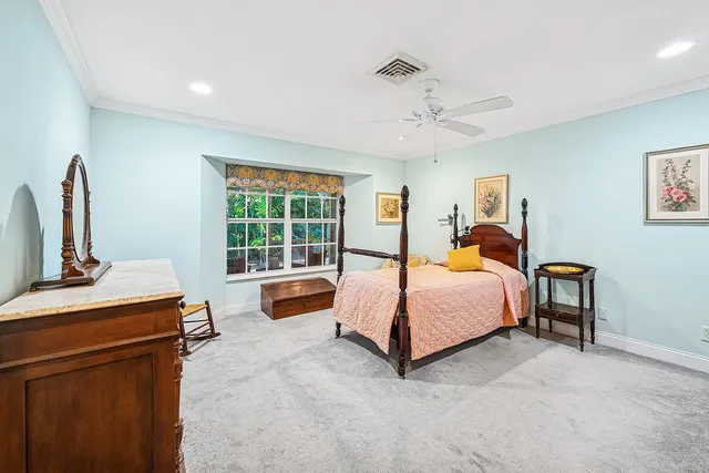a spacious bedroom with a bed a dresser and windows