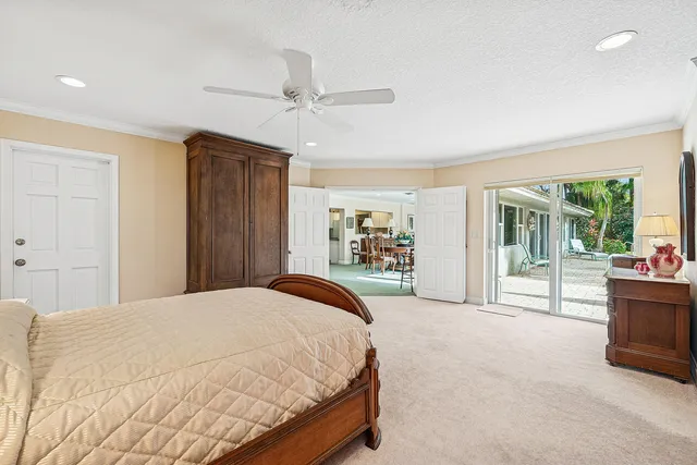 a bedroom with a bed and large windows