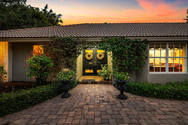 a view of a entryway door with potted plants