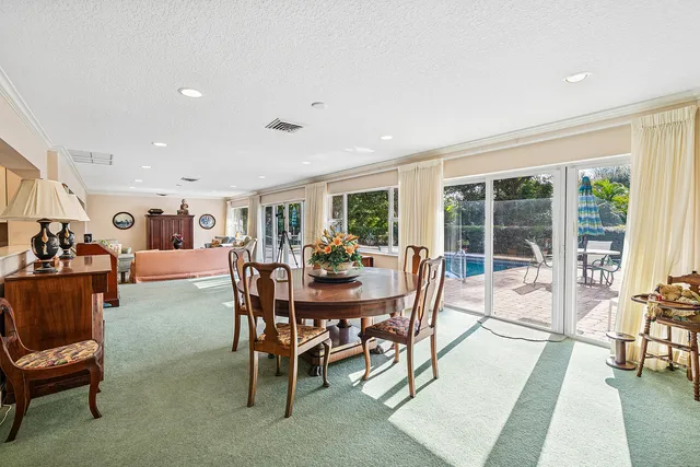a dining room with furniture a rug and a floor to ceiling window